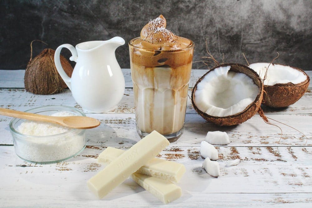 Café con coco y almendra servido en taza de cristal, receta cremosa y saludable